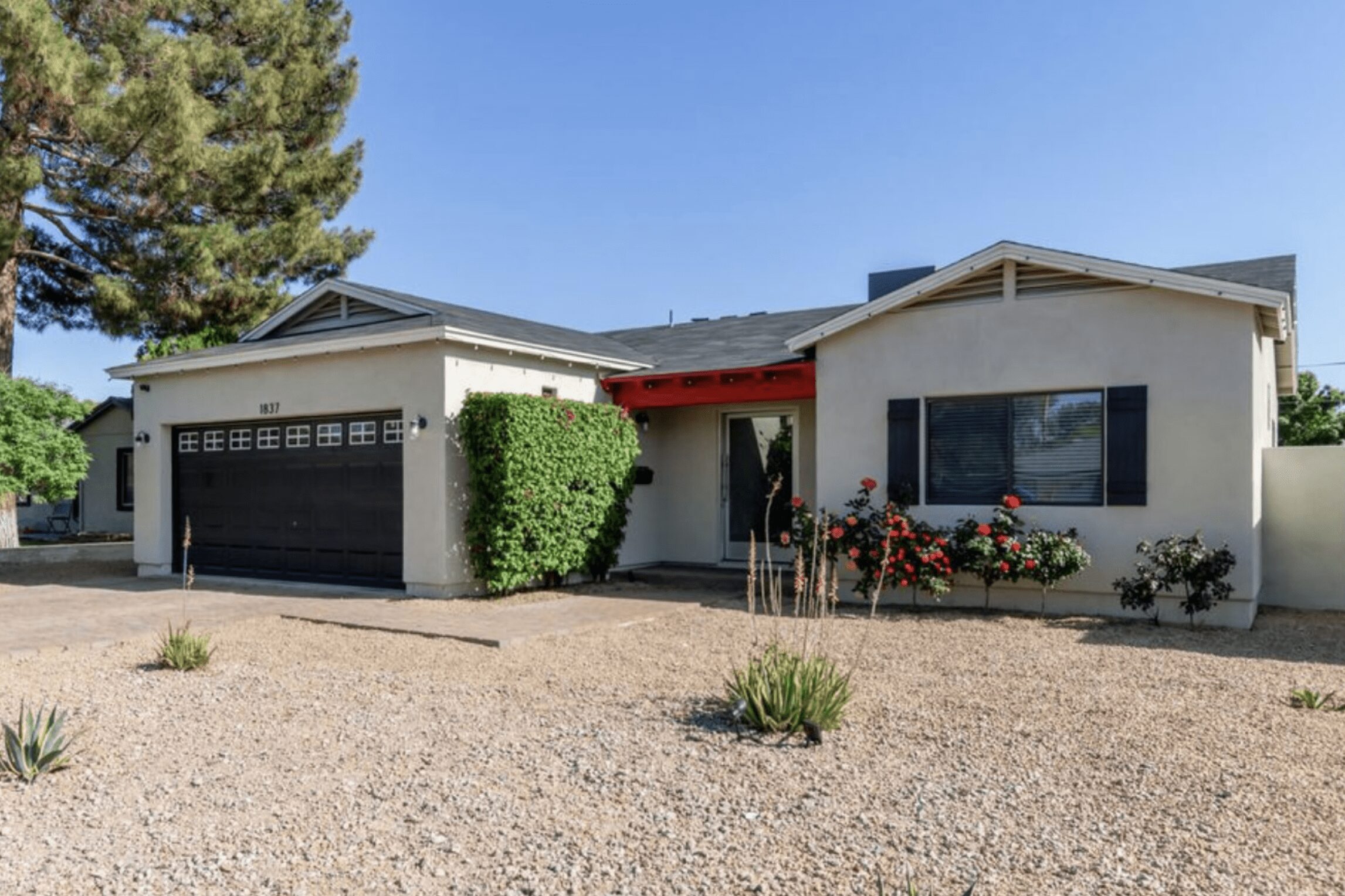 House in the desert with only a yucca plant in front and rock lawn.
