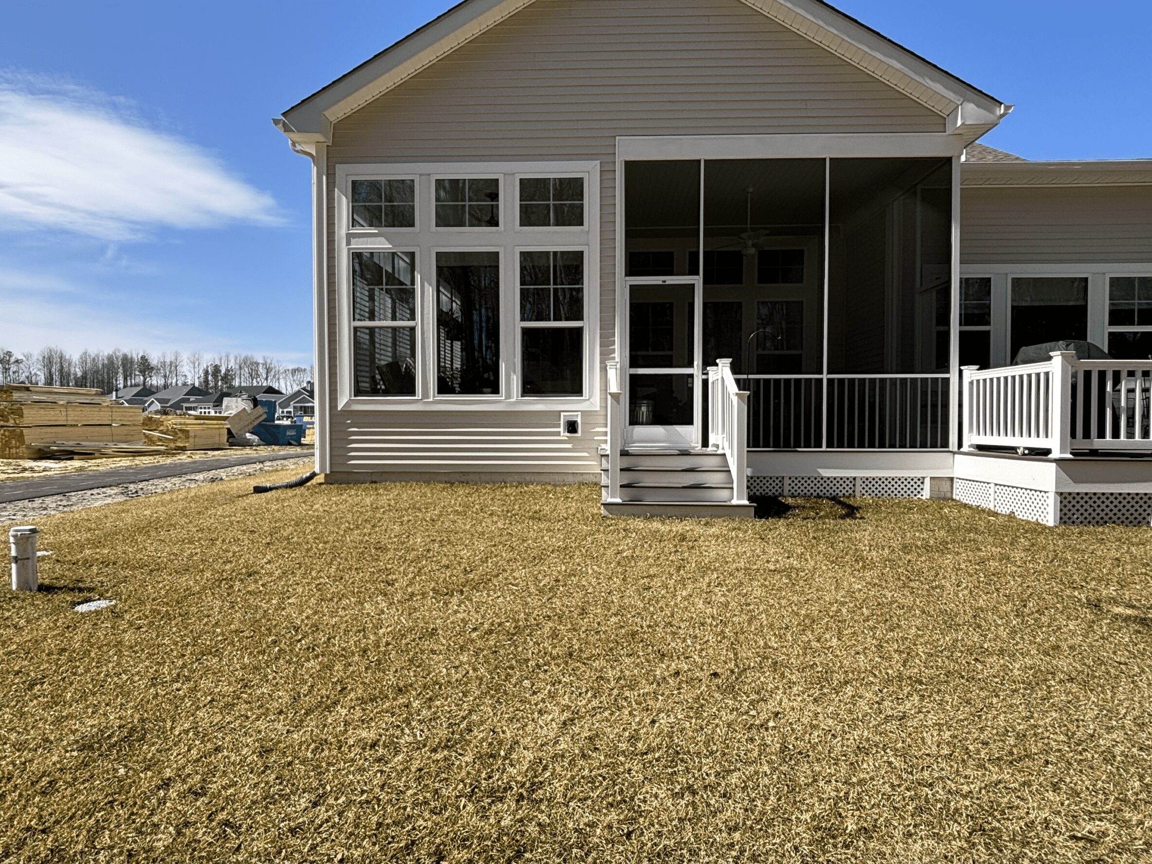 A new cream-colored house with no gardens or landscaping.