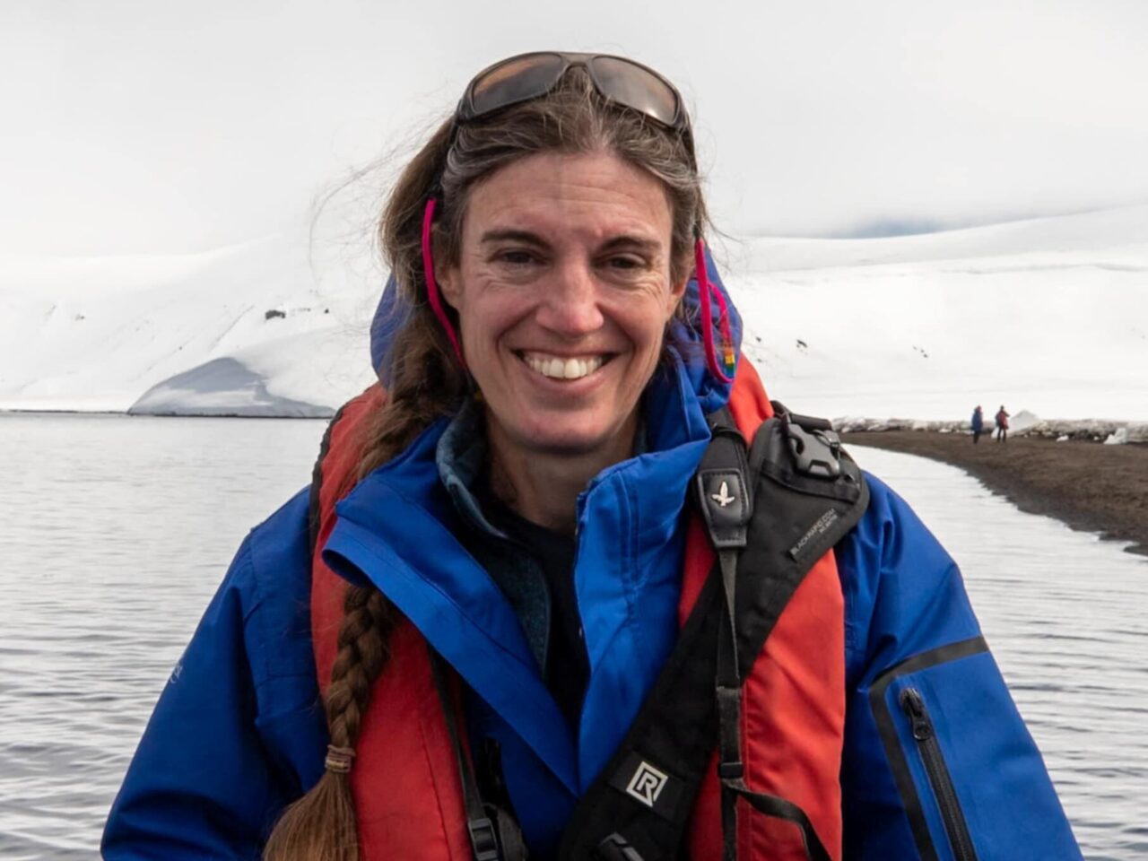 Woman in a boat on water in ice covered area.