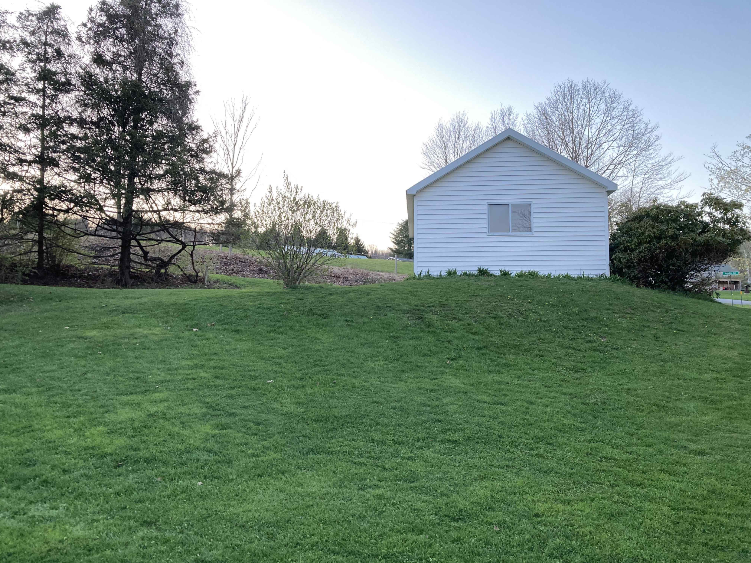 a grassy slope with a white building at the top