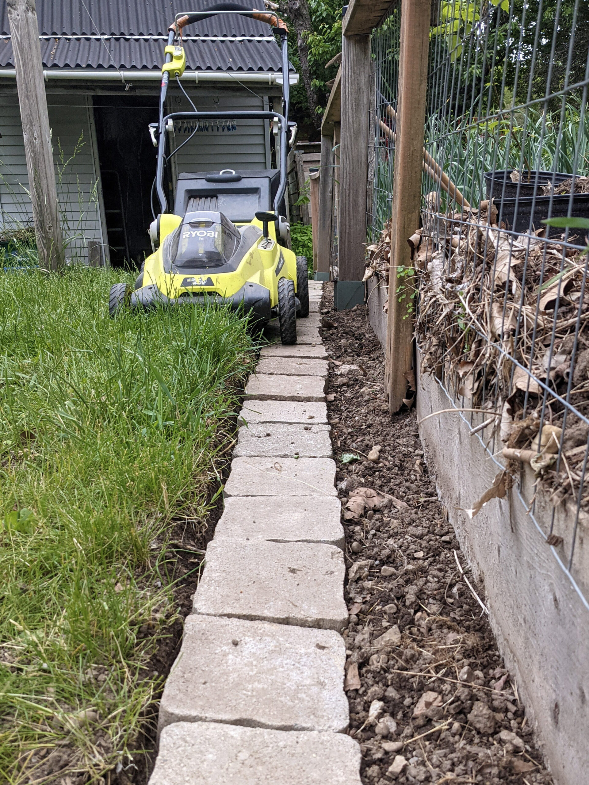 A lawnmower next to a new native plant garden