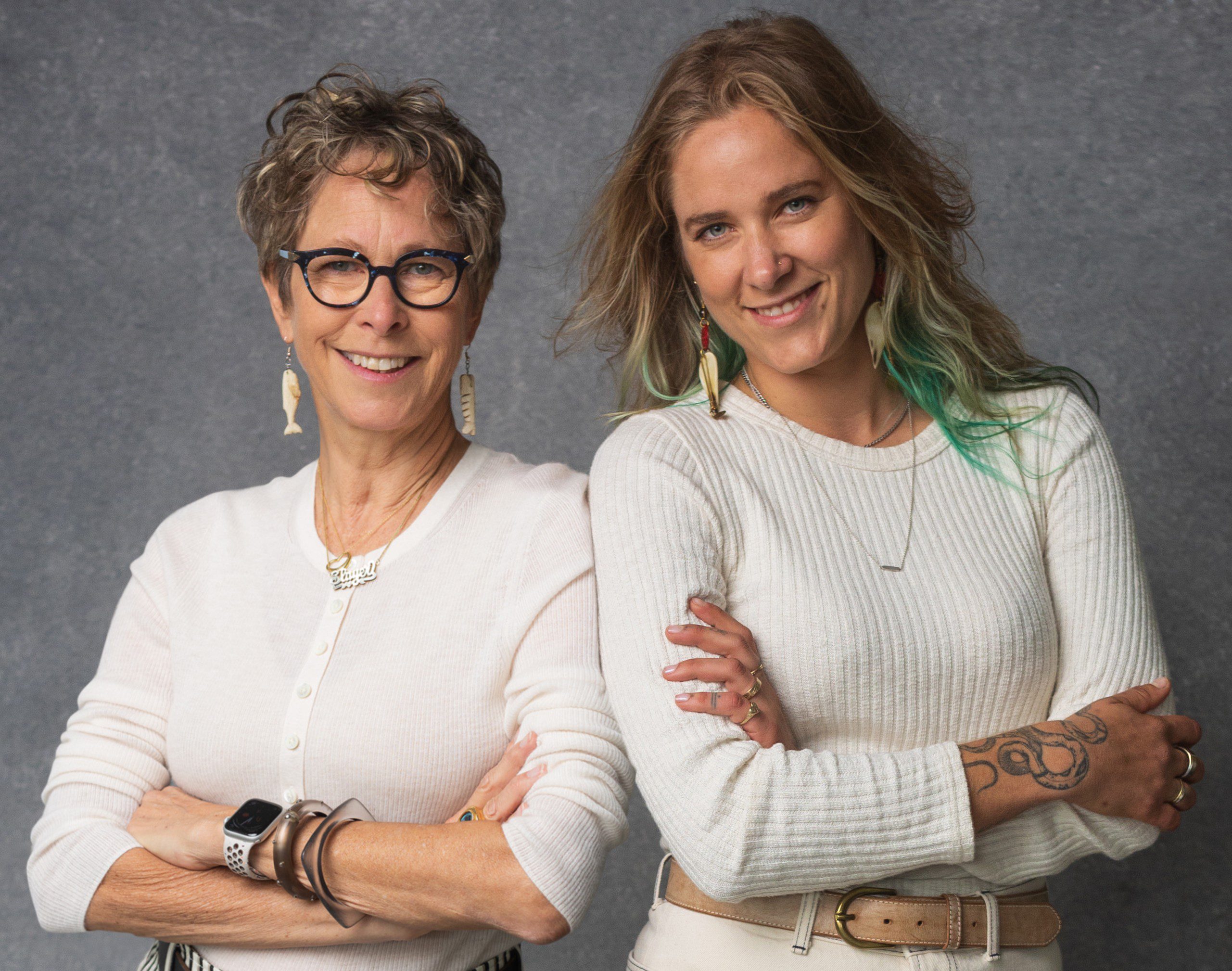 Two women with arms crossed.